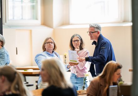 Drei Personen studieren eine Menükarte.