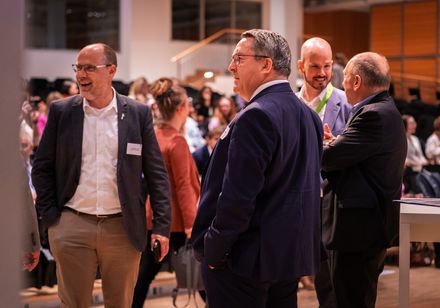 Vier Männer im Gespräch auf einer Veranstaltung