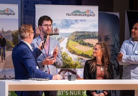 Ein Moderator im Gespräch mit einem Referenten.