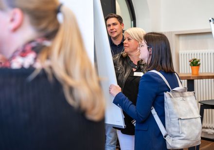 Zwei Personen machen während eines Workshops auf einem Flipchart Notizen.