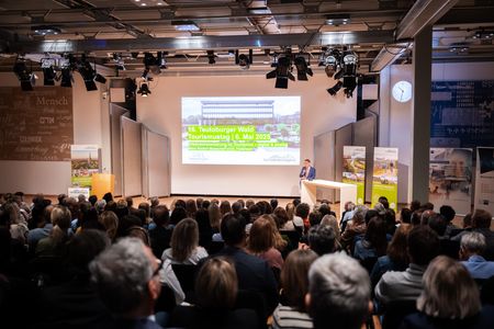 Das Foto zeigt den Moderator Jörg Brökel, der die rund 200 Zuschauer der Veranstaltung begrüßt.
