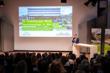 Ein Moderator begrüßt die Teilnehmenden zur Veranstaltung.