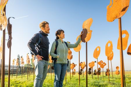 Zwei Personen schauen sich Metall Kunstwerke auf dem Nieheimer Kunstpfad an