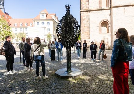 Geführter Rundgang einer Gruppe von Menschen an einer Kirche.
