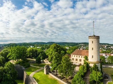 Rechts sieht man die Bielefelder Sparrenburg, im Hintergrund Wald und Teile der Stadt Bielefeld
