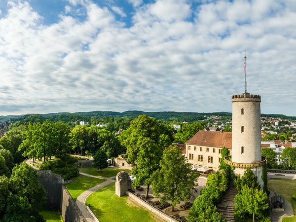 Rechts sieht man die Bielefelder Sparrenburg, im Hintergrund Wald und Teile der Stadt Bielefeld