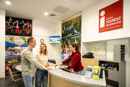 Ein Paar lässt sich in einer Tourist-Information beraten.