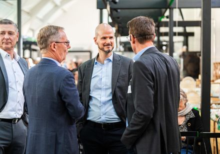 Drei Personen auf einem Event im Gespräch.