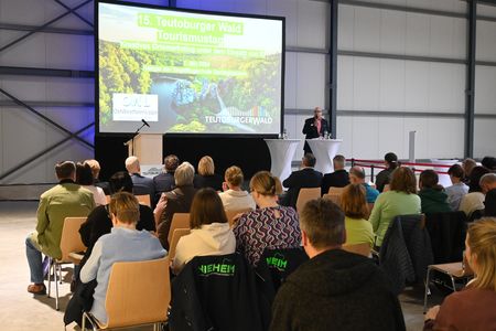 Auf dem Foto begrüßt ein Moderator die Zuschauer zur Veranstaltung.