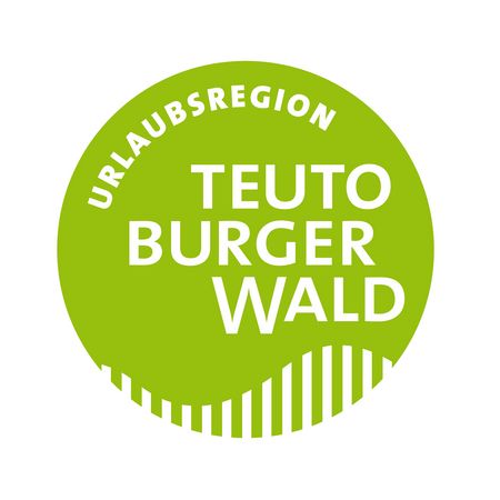 Ein runder hellgrüner Button mit dem Schriftzug Urlaubsregion Teutoburger Wald