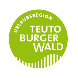 Ein runder, hellgrüner Button mit dem Schriftzug "Urlaubsregion Teutoburger Wald"