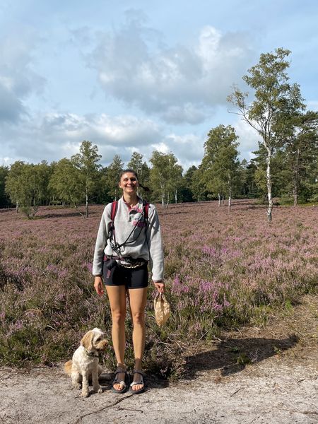 Lara in der Natur mit Heide im Hintergrund und Hund an der Leine