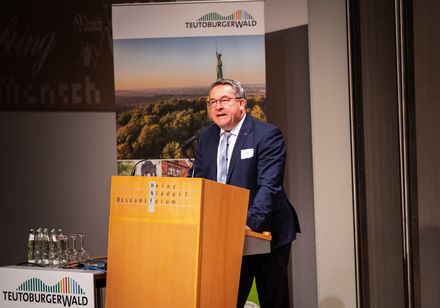 Ein Mann hält an einem Pult eine Rede.