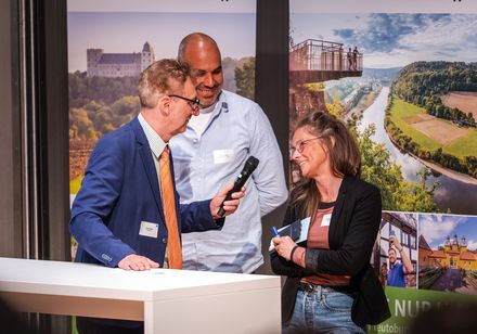 Ein Moderator und eine Referentin im Gespräch.