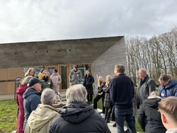 Eine Gruppe steht vor einem modernen Museumsbau.